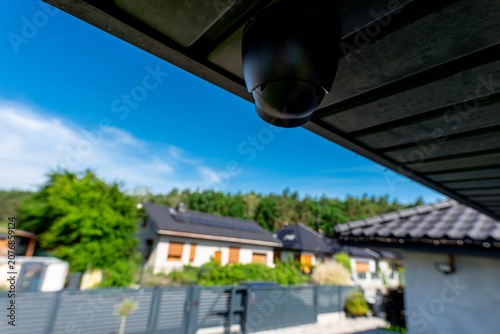 Security dome camera monitoring suburban home property