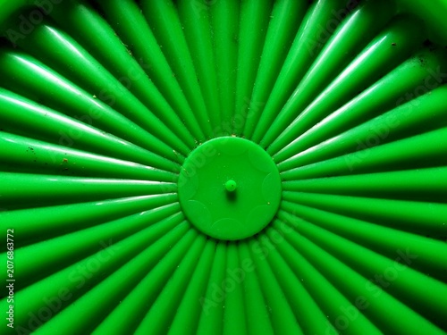 Close up of bright green plastic surface with radial lines and circular pattern texture  