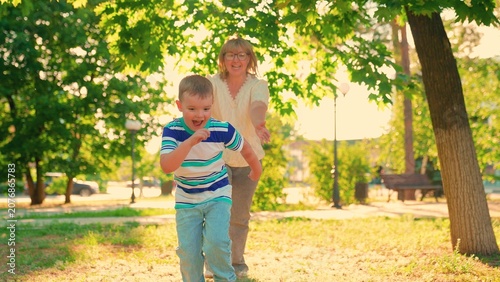 Konstfotografi Young son plays with mom, running together summer park