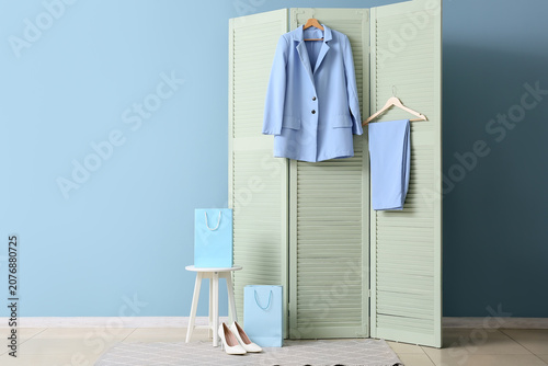 Fotografie Light blue womens suit jacket and pants with shopping bags and shoes