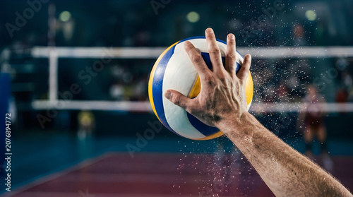 Volleyball serve action shot close up of hand contact with ball during game