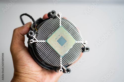 Фотография Hand holding computer processor on CPU air cooler for PC assembly, semiconductor technology and hardware upgrade