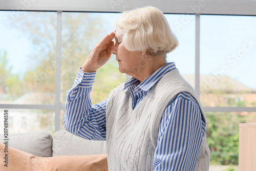 Thoughtful senior woman with dementia at home