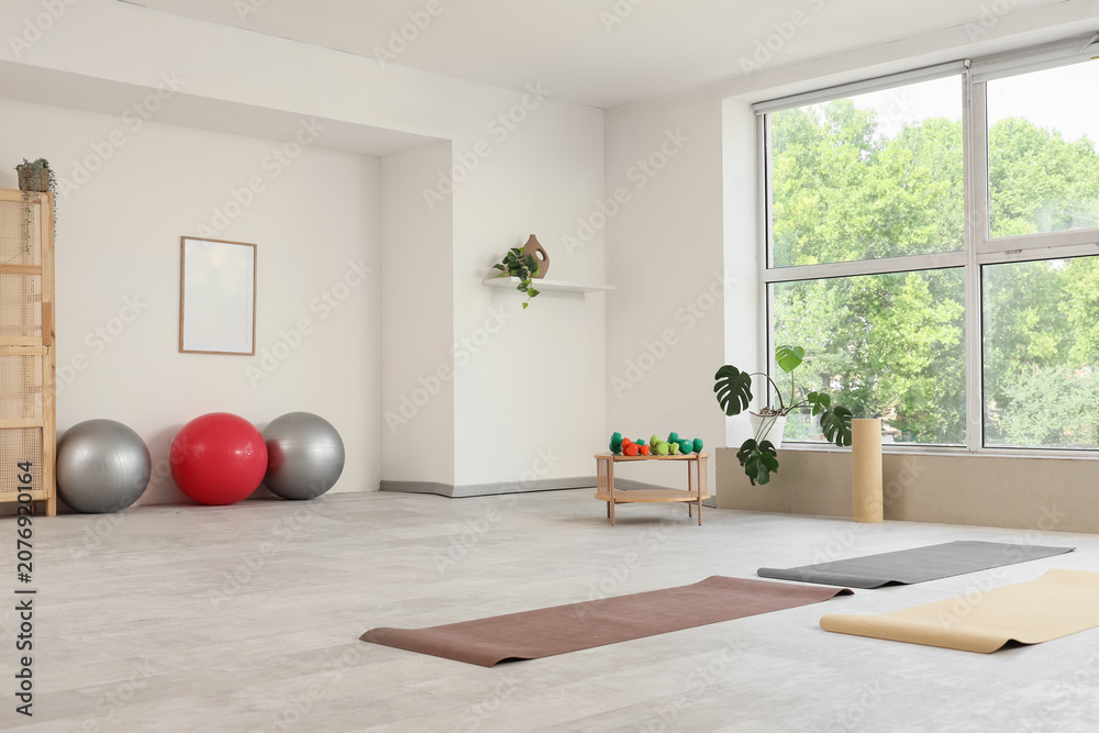 Obraz premium Interior of gym with sports equipment, table and window