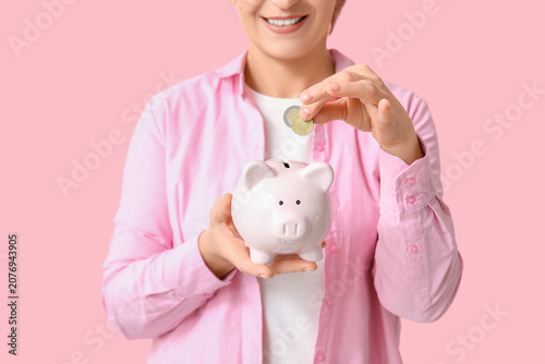 Mature woman putting coins ...