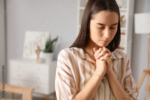 Beautiful young woman prayi...