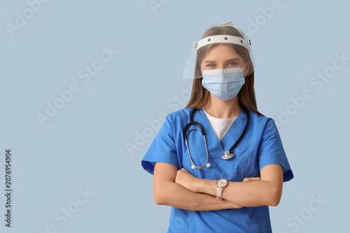 Female doctor in protective masks on blue background