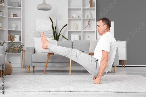 Mature man doing yoga at home