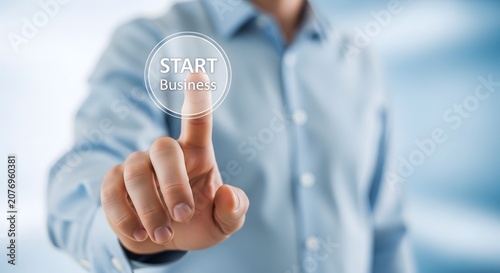 Business start up concept hand pressing 'start business' button