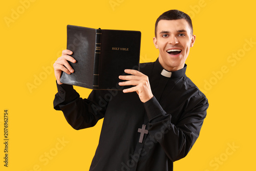 Young priest with Holy Bibl...