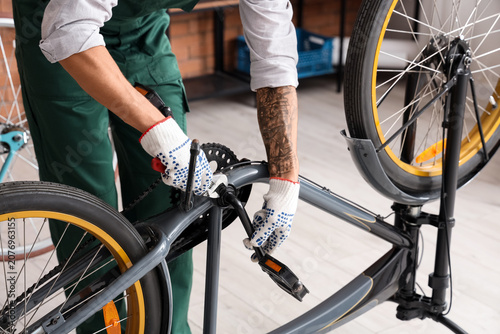Young mechanic repairing bi...