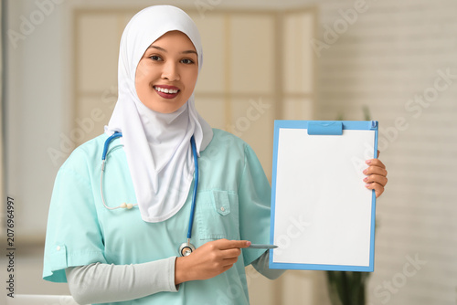 Female Muslim doctor pointi...