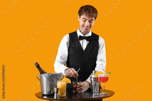 Young male bartender prepar...