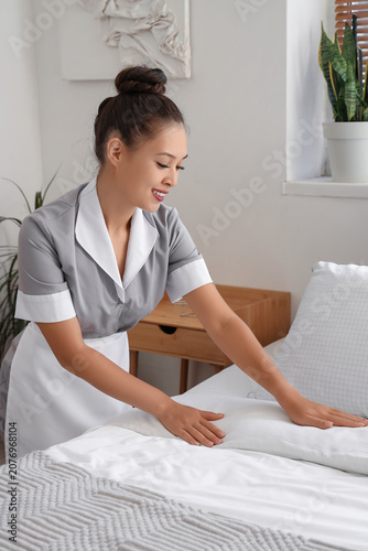 Pretty chambermaid making b...