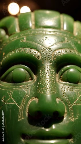 Close-up of green carved stone mask.