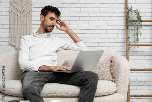 Handsome man using laptop a...