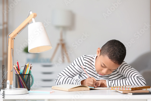 Little African-American boy doing lessons at home