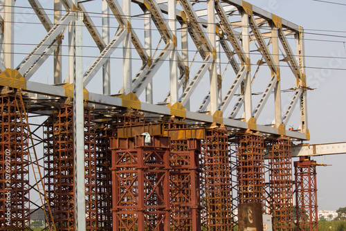 Fotografie Industrial bridge construction site featuring steel girder framework and tall sc