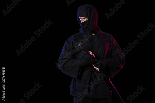 Foto Male ninja with sword on black background