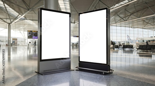 Two blank digital advertising screens in a modern airport terminal.