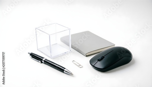 Minimalist Office Workspace Accessories with Wireless Mouse, Notebook, Pen, Paper Clip, and Transparent Acrylic Box on White Background