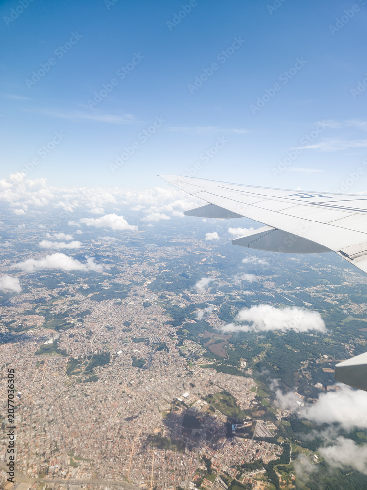 Fototapeta premium View from an airplane window looking out over beautiful clouds and blue sky during flight.
