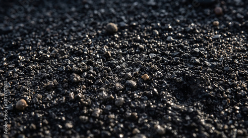 Natural black volcanic pebbles texture from a beach close up with volcanic background sediment