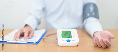 Foto Man checking Blood pressure by Blood pressure monitor with Cuff