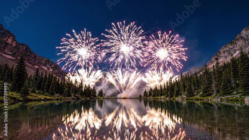 Celebrating USA Independence Day with vibrant fireworks reflected on a serene mountain lake at dusk