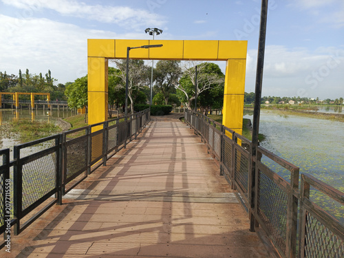 Yellow bridge over water with railing.