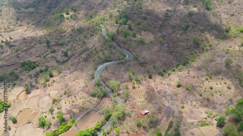 Beautiful aerial view of Wilson Hills located in Gujarat- India, A high-resolution aerial drone photograph of a winding mountain road featuring multiple hairpin bends through a dry deciduous forest