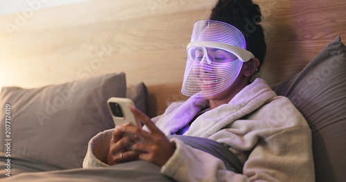 Tableau sur toile Blue light, skincare and woman with phone in bedroom for beauty, wellness or antibacterial facial