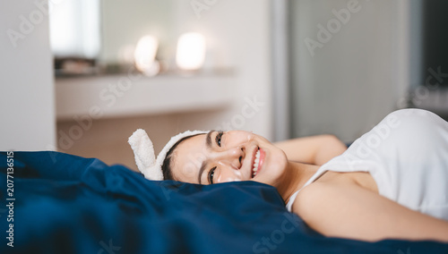 Photography Beautiful smiling young asian woman, relax lying in bed with eye sheet mask enjo