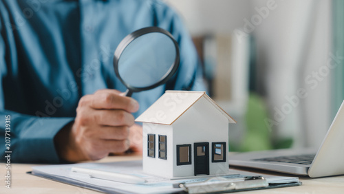 Photos Professional agent holds magnifying, house model sits on office desk, expert ins