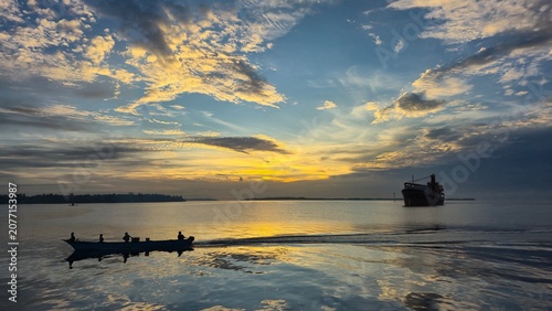 Silhouette of boats on a calm sea during a vibrant sunset