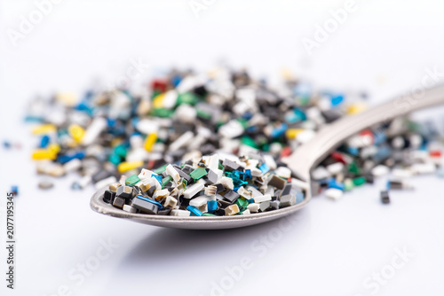 Close-up of a spoon filled with colourful microplastic waste