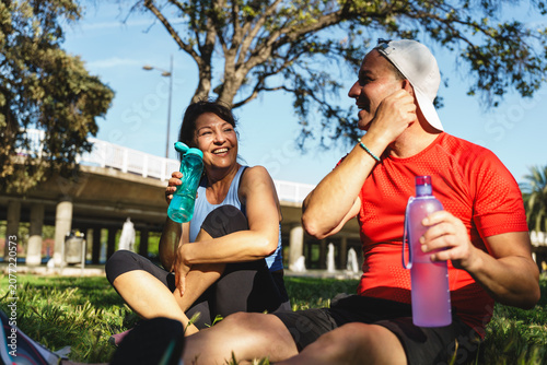 Принти на полотні Senior couple relaxing and hydrating with water bottles after outdoor exercise