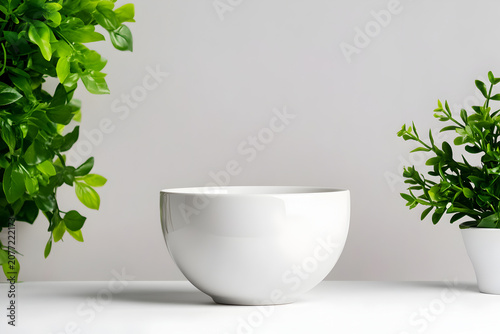 A White Ceramic Bowl Between Green Plants