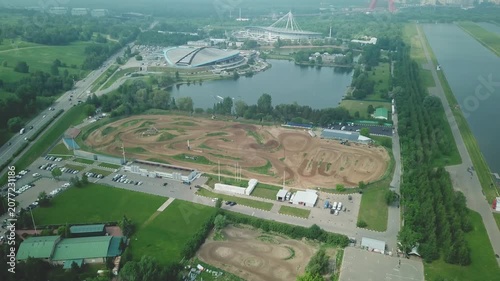 Drone flying forward and down over motocross track