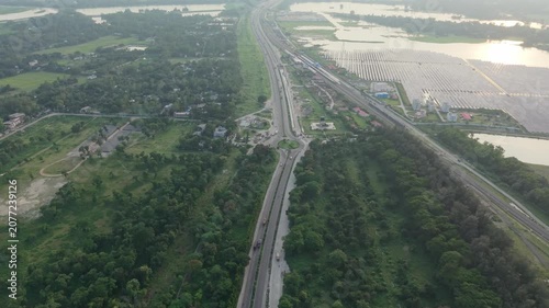 Highway Aerial View Through Green Forest Toward a River Delta at Golden Hour, Showing Traffic Lanes and Landscape