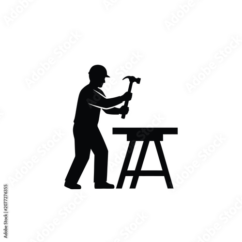 Silhouette of a construction worker hammering on a workbench.
