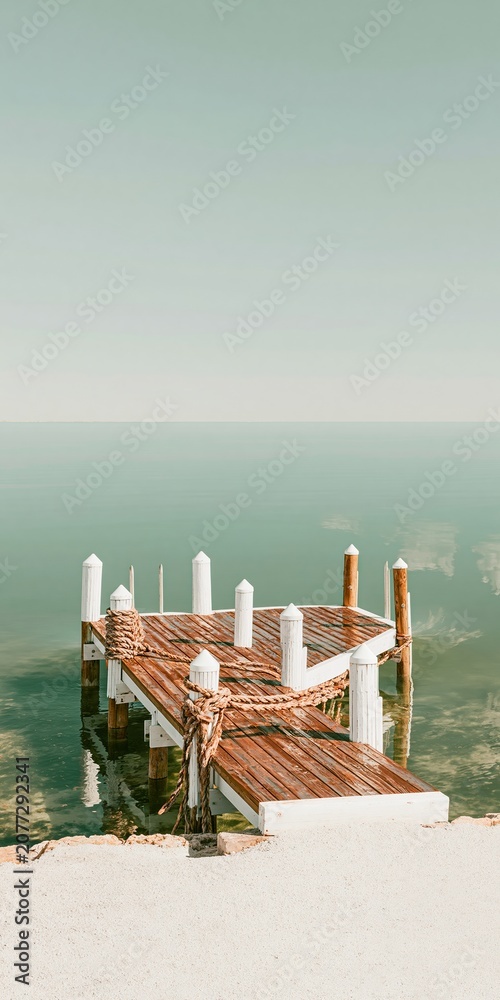 Fototapeta premium A surreal harbor with a lifting water surface and glossy wood dock, illustrating coastal resilience and climate change concepts with copy space