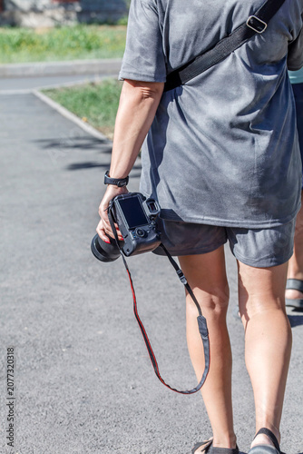 Photographer walks with camera held firmly