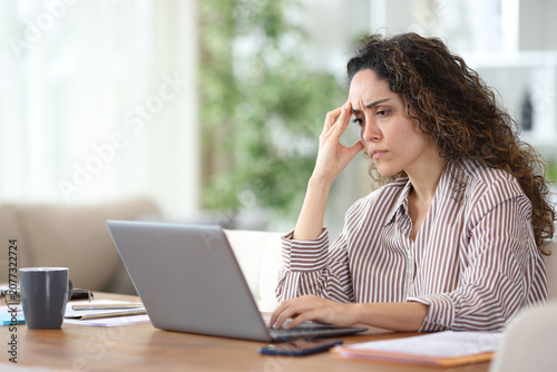 Bild auf Leinwand Worried adult teleworker using laptop working at home