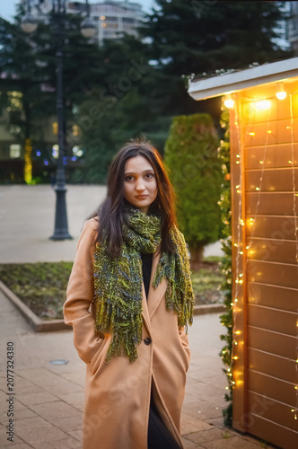 Portrait of a beautiful young woman on the street in the evening twilight. Vertical photograph.