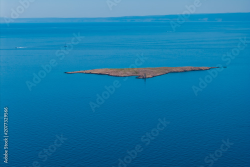 Foto Small uninhabited rocky islet surrounded by the Adriatic Sea near Stara Baška, K