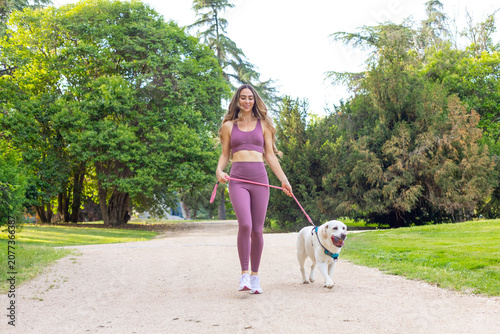 Young woman enjoying outdoor walk with labrador dog