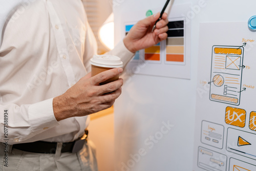 Fotografía Close-up of a UX designer reviewing wireframes, interface layouts, and visual design elements on a planning board for user interface development, usability testing, and digital product design