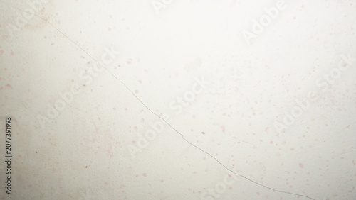 Photos White plaster wall with long diagonal hairline crack and subtle stain marks