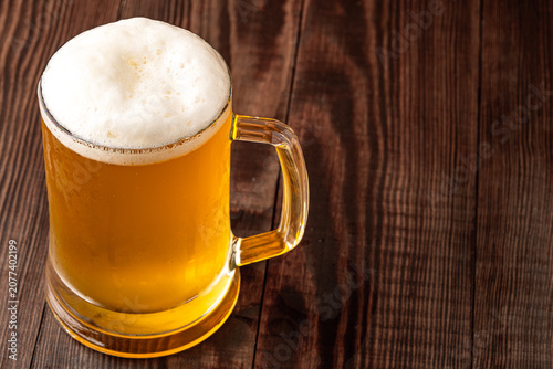 Glass of cold beer on wooden background